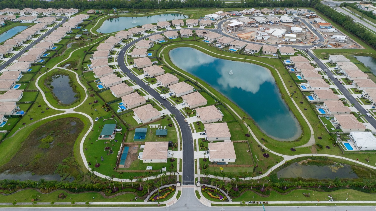 Bird's eye view of master-planned community in Collier County Florida with new construction homes, lakes, parks, and walking trails, vibrant green landscape, 8K aerial photorealistic