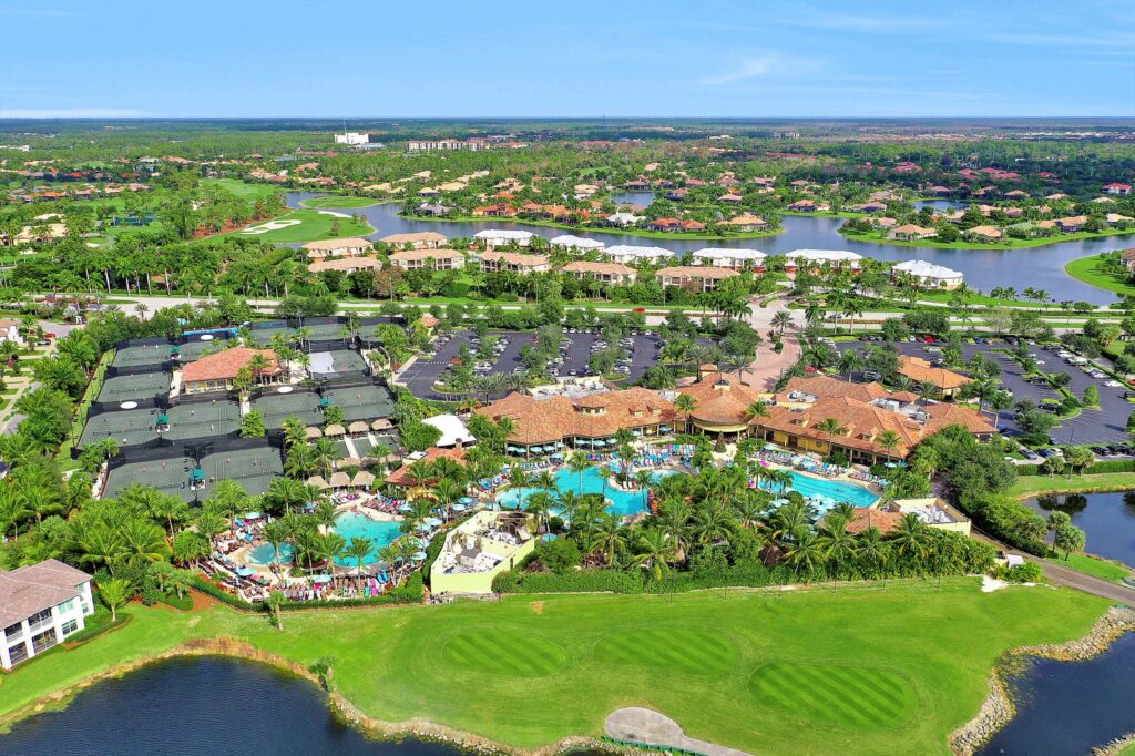 Photorealistic 8K hero shot of Lely Resort main entrance with lush landscaping, palm trees, and elegant signage on a clear Florida day, clean centered composition, premium gradient background, studio-grade lighting