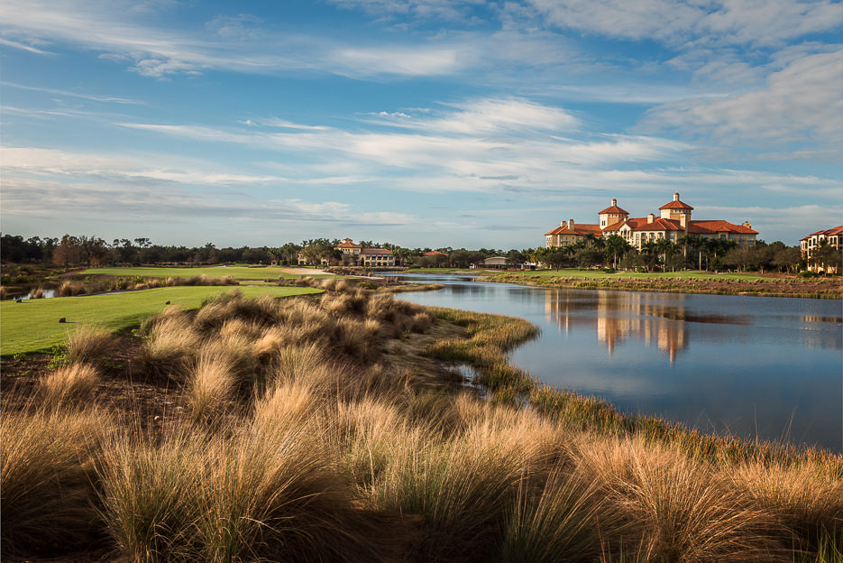 Photoreal 8K hero shot of Tiburón Golf Club entrance with elegant Mediterranean signage, manicured palms, and soft golden hour light on white background, studio-grade luxury real estate photography, centered composition